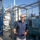 Man stands among pipes and tanks